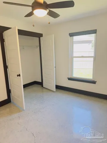 an empty room with a ceiling fan and a window