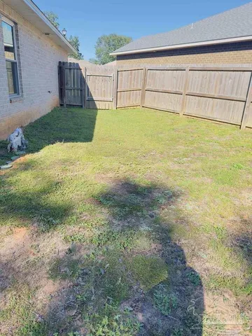 a view of backyard with wooden fence