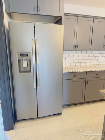 a view of a refrigerator in kitchen and a sink
