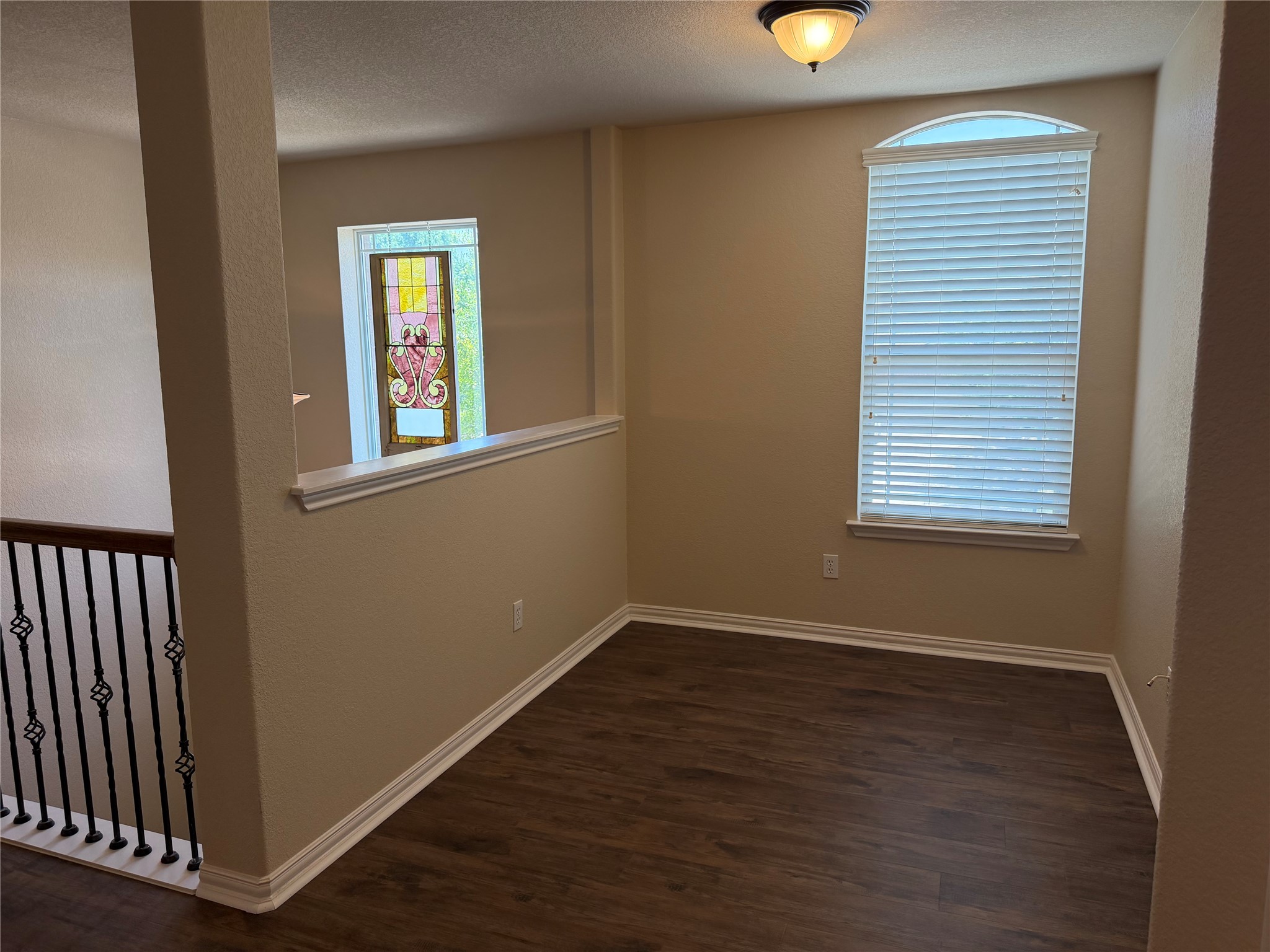3021 Grand Mission Way Pflugerville, TX 78660 - Photo 21 of 31 Rich wood-look flooring and an ornate stained-glass window create a distinctive interior aesthetic.