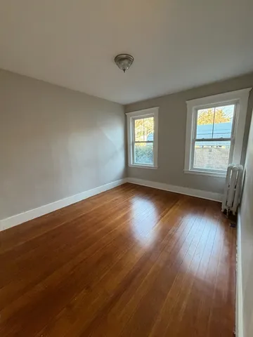 a view of a livingroom with wooden floor and window