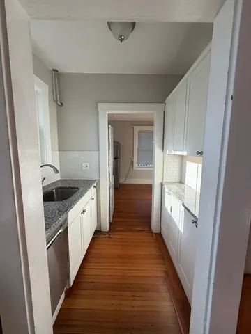 a kitchen with granite countertop a sink and a stove top oven