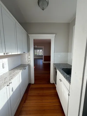 a kitchen with granite countertop a sink and cabinets