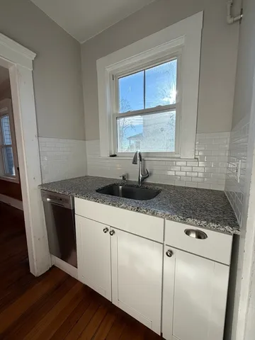 a kitchen with granite countertop a sink a window a washer and dryer