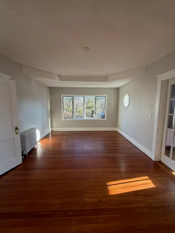 a view of room with window and wooden floor