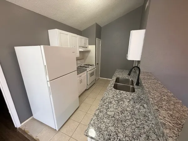 a white refrigerator freezer sitting in a kitchen