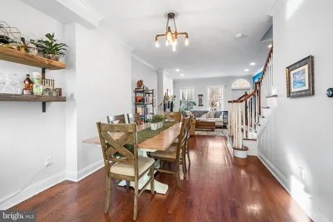 a dining room with furniture a chandelier and wooden floor