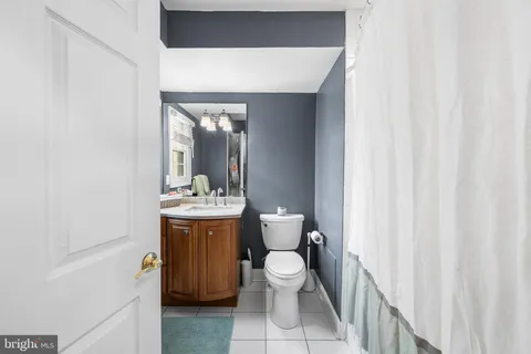 a bathroom with a sink a toilet and shower curtain