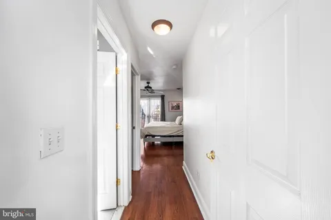 a view of a hallway with wooden floor and furniture