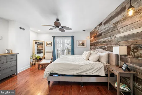 a spacious bedroom with a bed and wooden floor