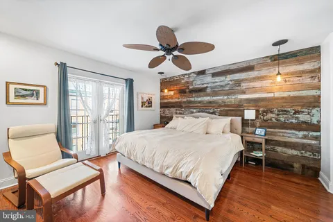 a bedroom with a bed and wooden floor