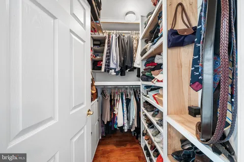 a view of walk in closet with clothes and shoes