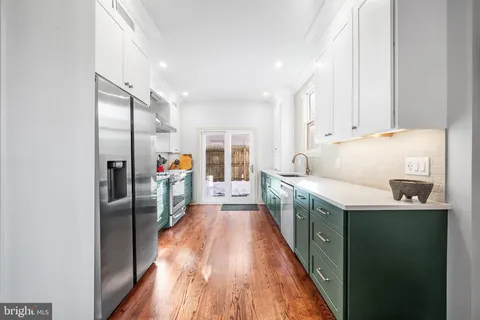 a kitchen with stainless steel appliances granite countertop a refrigerator and a sink