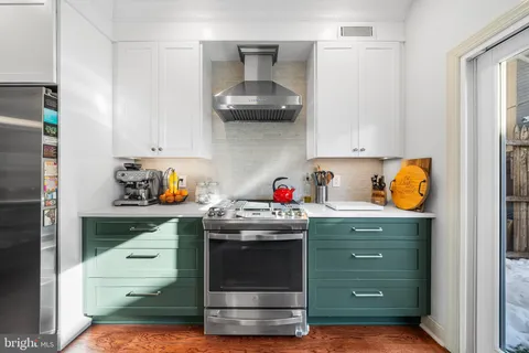 a kitchen with granite countertop a stove and cabinets