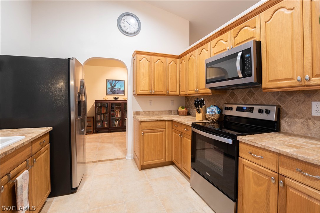 9115 Irving Road Fort Myers, FL 33967 - Photo 17 of 35 a kitchen with stainless steel appliances granite countertop a stove a sink and a microwave