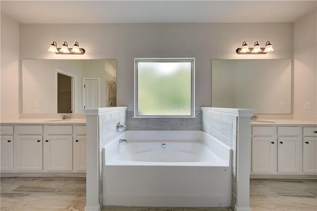 a bathroom with a bathtub sink and mirror