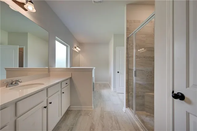 a spacious bathroom with a double vanity sink a mirror and shower