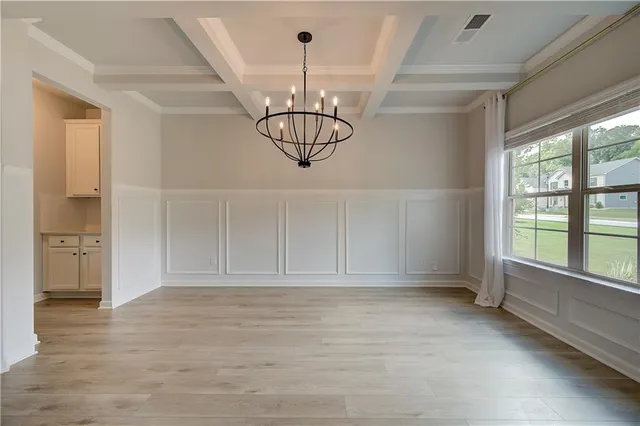 a view of empty room with window and chandelier