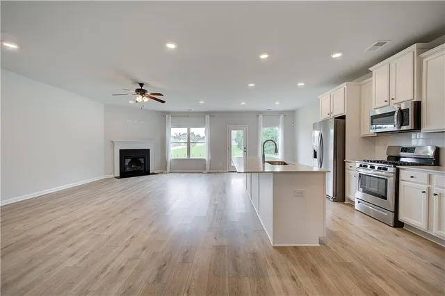 a view of kitchen with microwave a stove and wooden floor