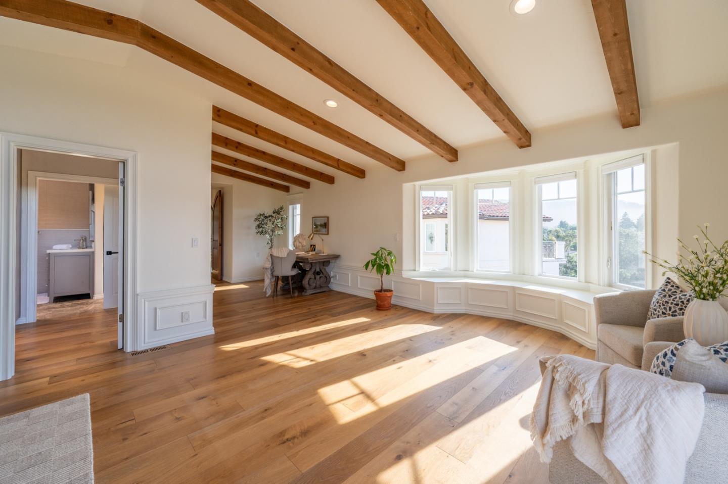 26345 Ladera Drive Carmel, CA 93923 - Photo 24 of 41 a spacious bedroom with a large bed a chandelier and windows