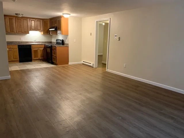 a large kitchen with stainless steel appliances granite countertop a refrigerator and a stove top oven