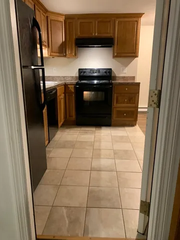 a kitchen with granite countertop a refrigerator and a stove top oven