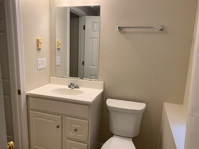 a bathroom with a toilet sink and mirror
