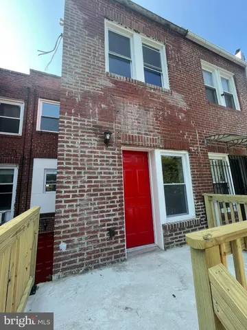 a brick building with a bench in front of door