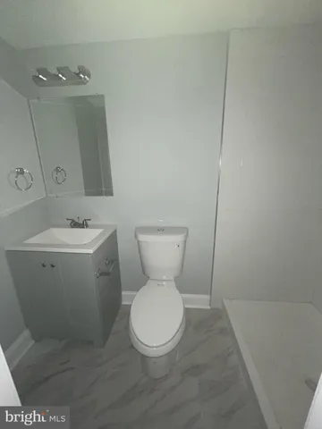 a white toilet sitting next to a bathroom sink