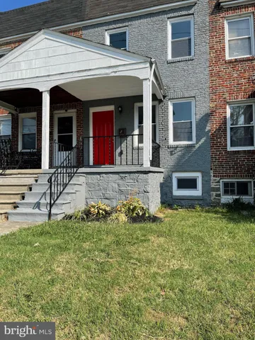 front view of a brick house with a yard