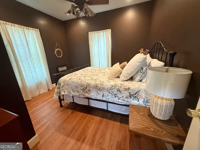 a bedroom with bed and wooden floor