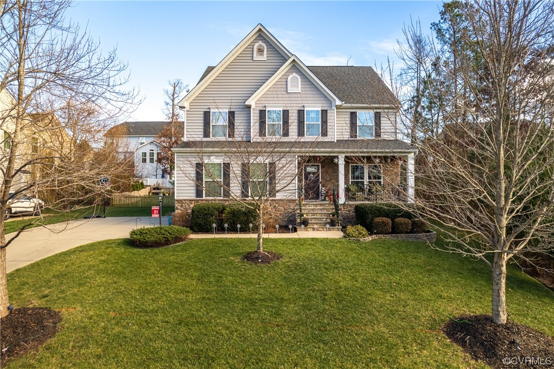 a front view of a house with a yard and trees