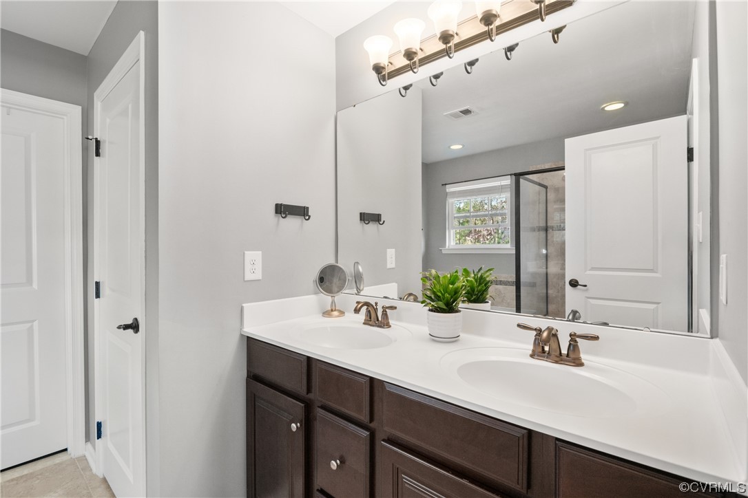 7031 Crackerberry Drive Moseley, VA 23120 - Photo 21 of 47 a bathroom with a double vanity sink a mirror and a shower
