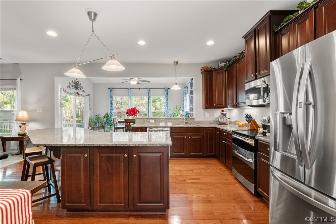 7031 Crackerberry Drive Moseley, VA 23120 - Photo 8 of 47 a kitchen with kitchen island granite countertop wooden cabinets and stainless steel appliances