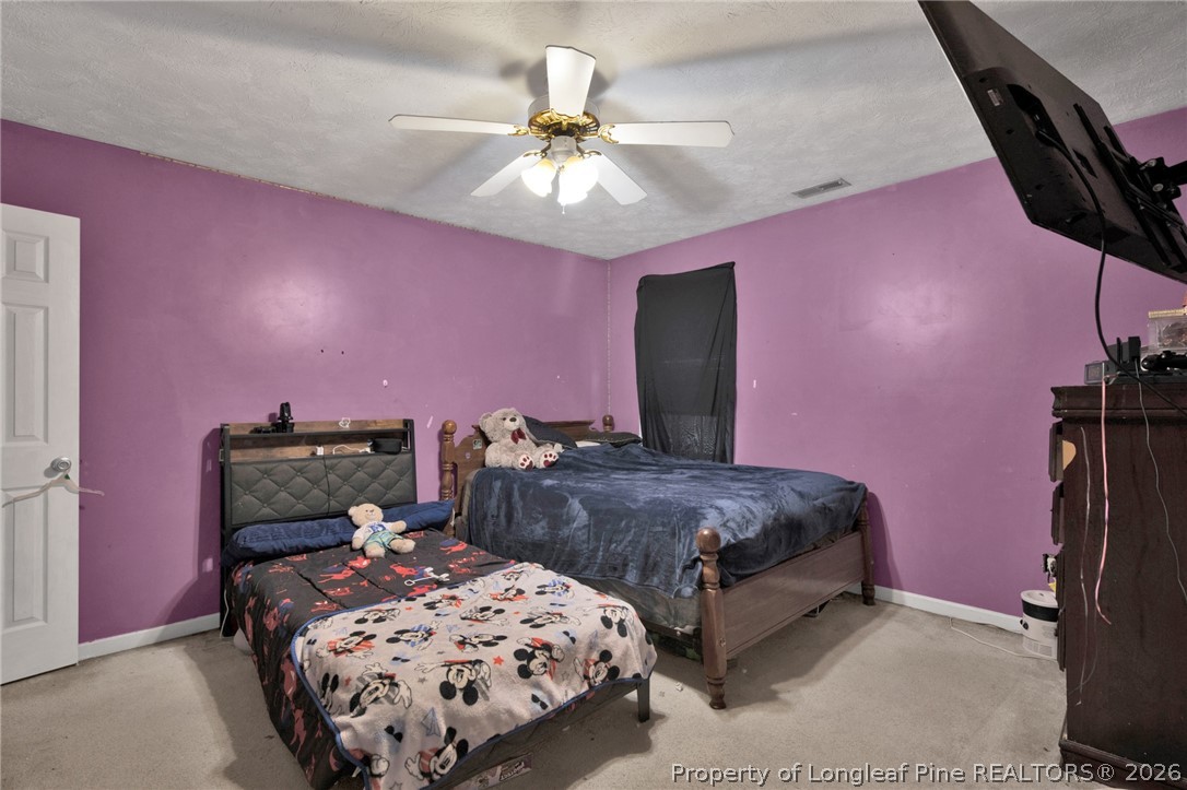 429 Bristlecone Road Fayetteville, NC 28311 - Photo 23 of 38 a bedroom with a bed and a chandelier