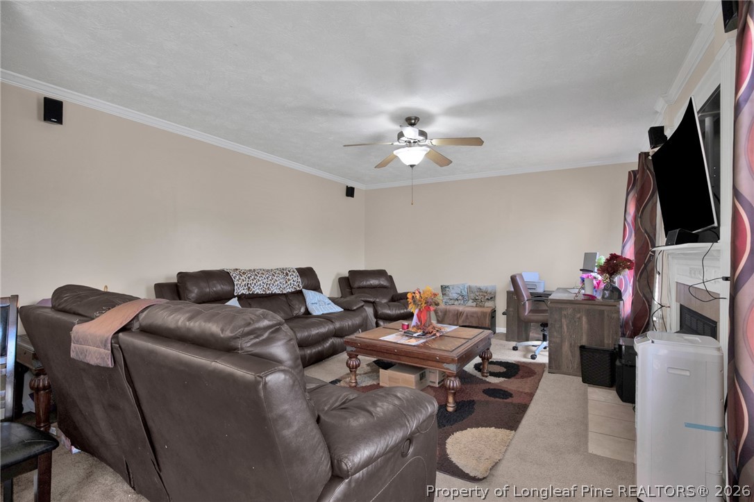 429 Bristlecone Road Fayetteville, NC 28311 - Photo 10 of 38 a living room with furniture a fireplace and a flat screen tv