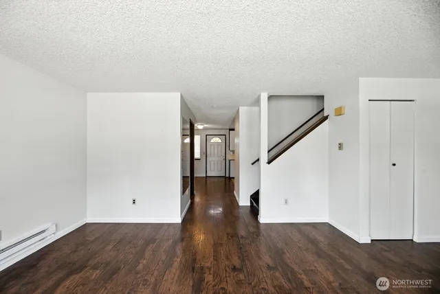a view of a hallway with wooden floor and stairs