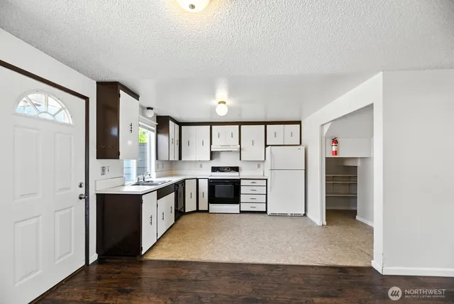 a large kitchen with a stove and a refrigerator