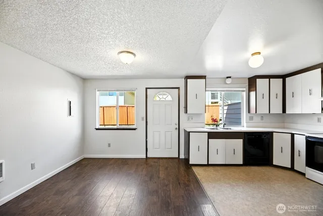 a view of a kitchen with wooden floor and window