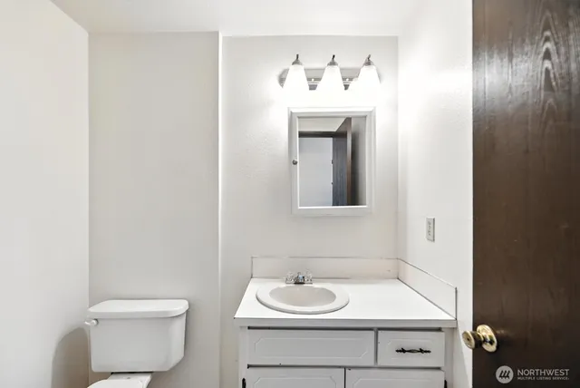 a bathroom with a toilet sink and mirror