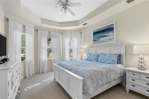 a bedroom with a large bed and flat tv screen on dresser