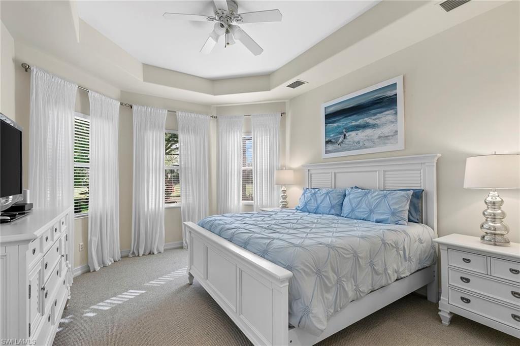 7778 Ashton Road Naples, FL 34113 - Photo 14 of 26 a bedroom with a large bed and flat tv screen on dresser