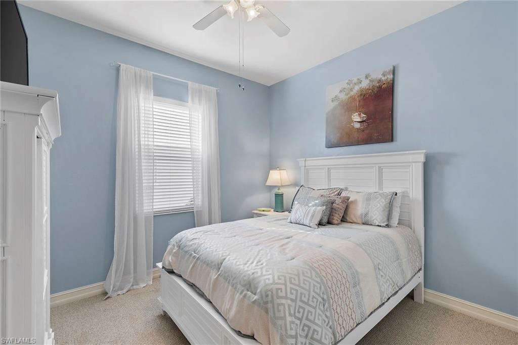 7778 Ashton Road Naples, FL 34113 - Photo 16 of 26 a bedroom with a bed and a chandelier