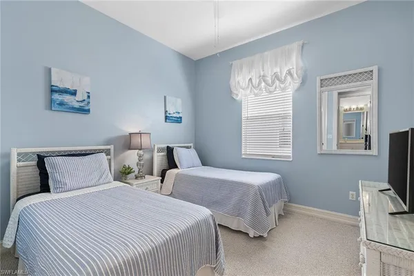 a bedroom with two beds and a window