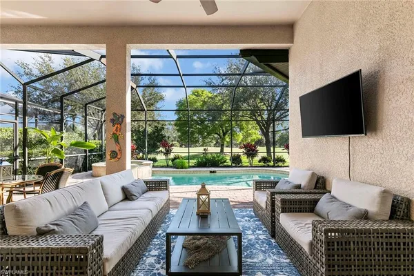 a living room with furniture a flat screen tv and a floor to ceiling window