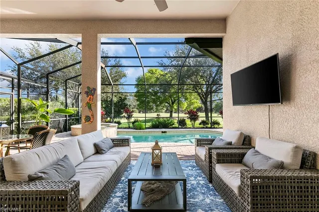 a living room with furniture a flat screen tv and a floor to ceiling window