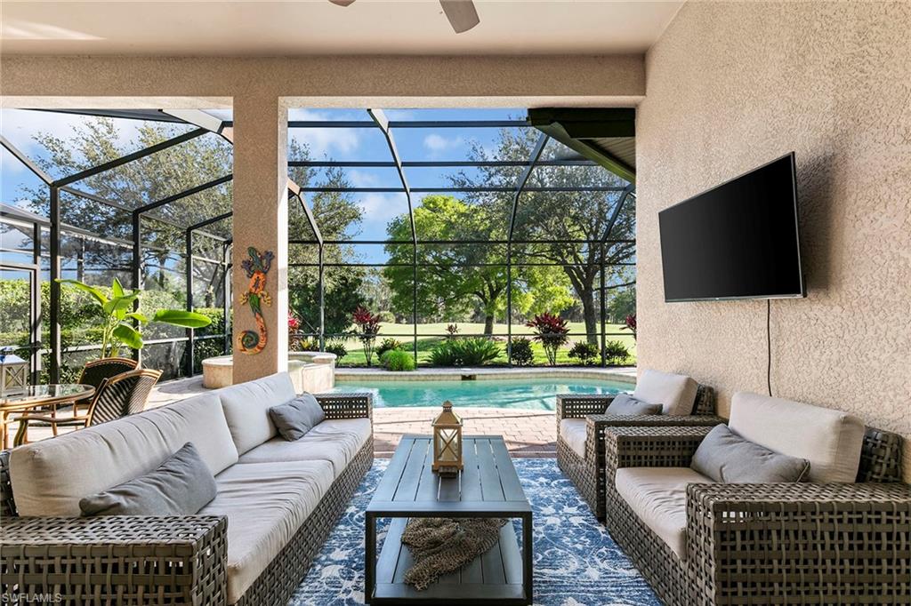 7778 Ashton Road Naples, FL 34113 - Photo 21 of 26 a living room with furniture a flat screen tv and a floor to ceiling window