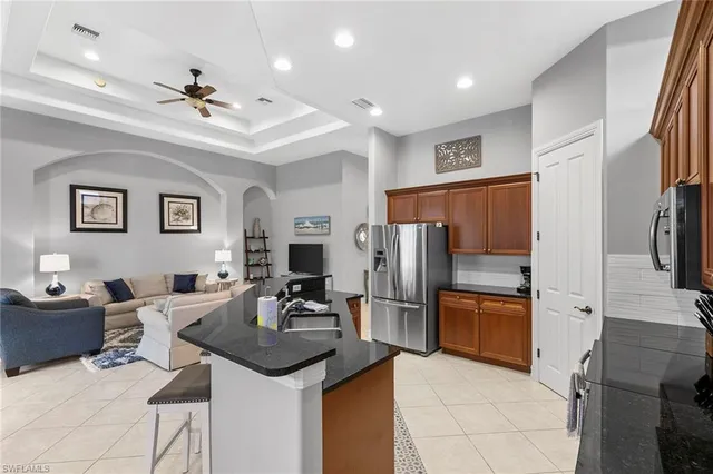 a kitchen with stainless steel appliances kitchen island granite countertop a refrigerator and a sink