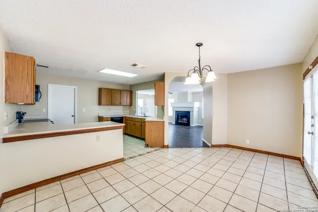 a large kitchen with kitchen island granite countertop a stove a sink dishwasher and a refrigerator with wooden floor