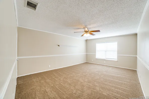 an empty room with a window and ceiling fan